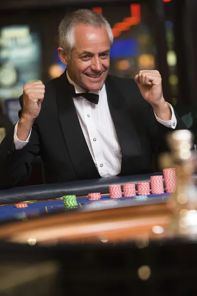 Uomo che celebra la vittoria al tavolo della roulette — Foto Stock