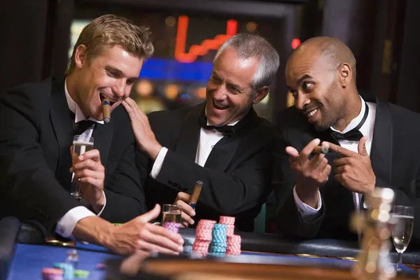 Tres hombres apostando en la mesa de ruleta — Foto de Stock