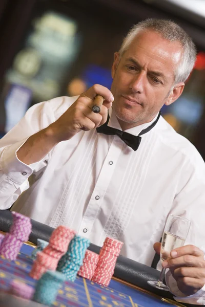 Uomo gioco d'azzardo al tavolo della roulette — Foto Stock