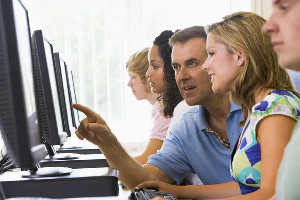Teacher assisting college student in a computer lab — Stock Photo, Image