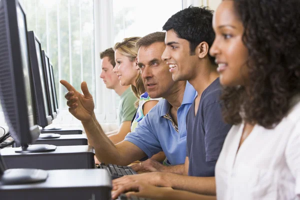 Tanár főiskolai hallgató segítése egy számítógépes laborban — Stock Fotó