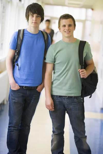 Estudantes universitários do sexo masculino em pé no corredor universitário — Fotografia de Stock