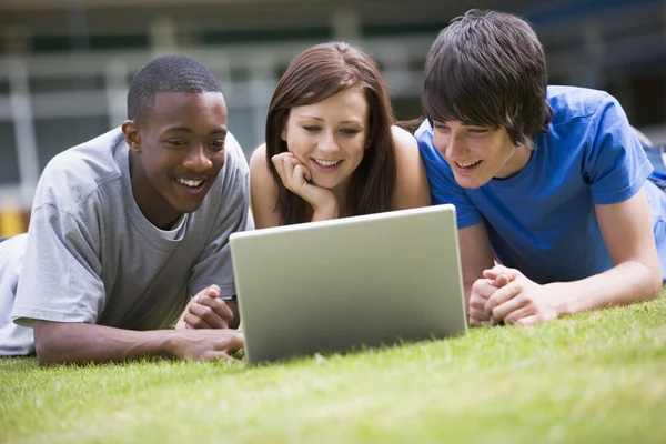 Üniversite Öğrencileri Kampüs Çimlerinde Dizüstü Bilgisayar Kullanıyorlar — Stok fotoğraf