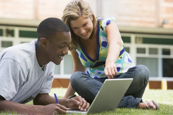 Üniversite öğrencileri kampüs çimlerinde dizüstü bilgisayar kullanıyorlar — Stok fotoğraf