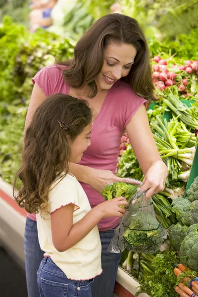 Mother and daughter in produce section — Stock Photo, Image
