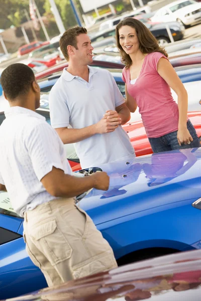 Casal discutindo carro novo com vendedor — Fotografia de Stock