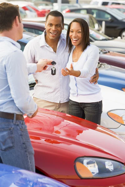 Couple picking up new car from salesman — Stock Photo, Image