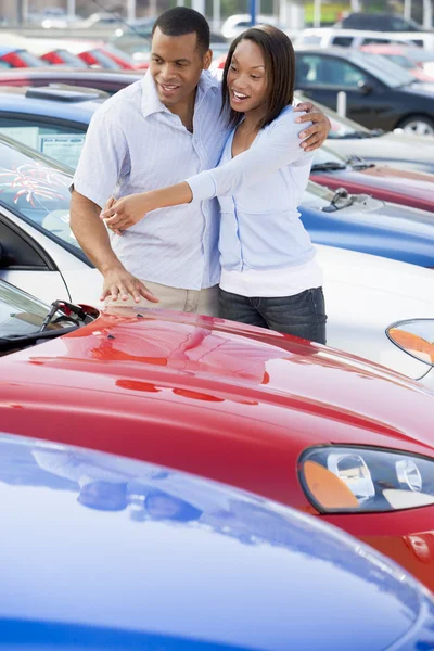 Young couple looking at new cars — Stock Photo, Image