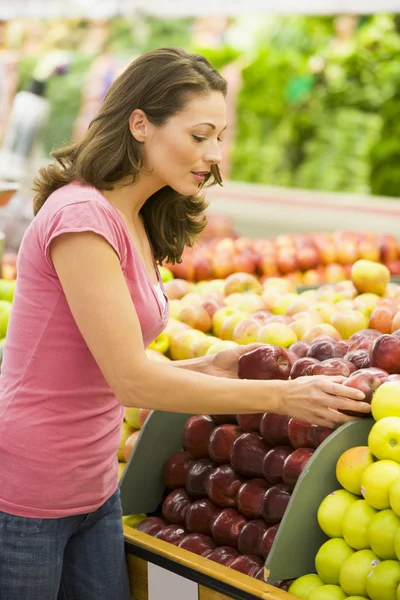 Mujer eligiendo manzanas en el departamento de productos —  Fotos de Stock
