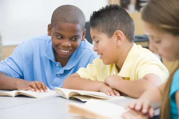 Dwóch Chłopców Dyskusji Temat Książki Podczas Gdy Siedzi Biurku — Zdjęcie stockowe