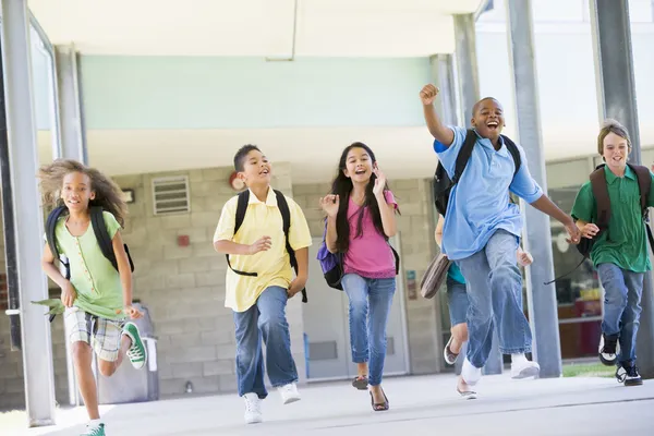 Ученики начальной школы бегают снаружи — стоковое фото