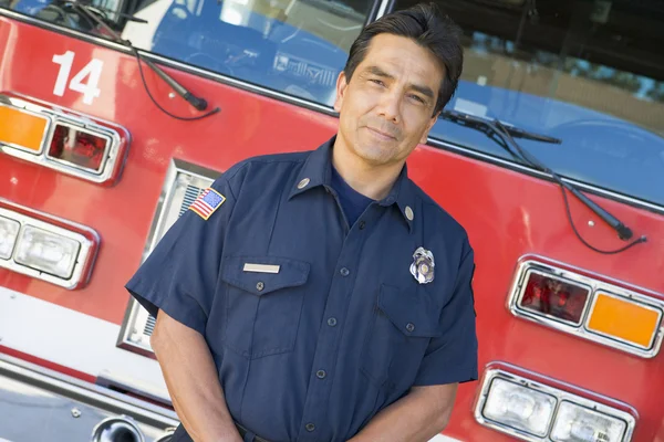 Portrait of a firefighter by a fire engine — Stock Photo, Image