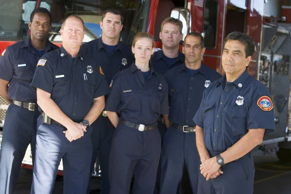 Portrait of firefighters standing by a fire engine — Stock Photo, Image