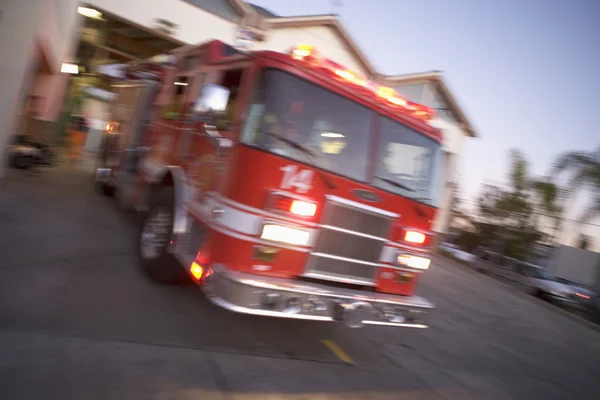 Um carro de bombeiros a sair de um quartel de bombeiros — Fotografia de Stock