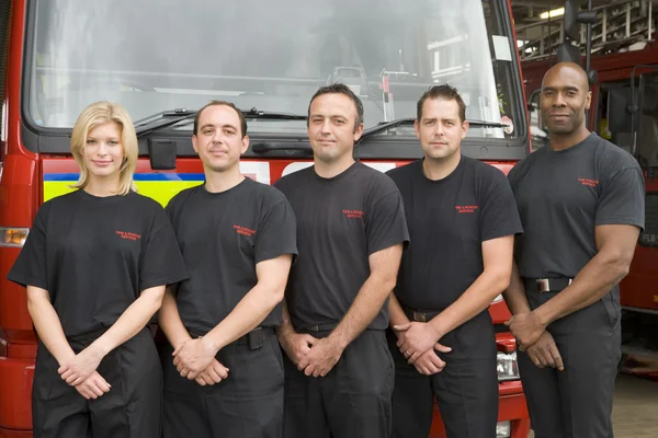 Porträt von Feuerwehrleuten, die neben einem Löschfahrzeug stehen — Stockfoto
