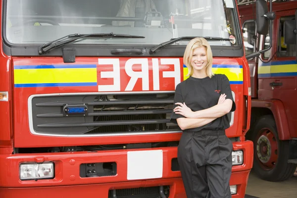 Portrait of a firefighter standing by a fire engine — Stock Photo, Image