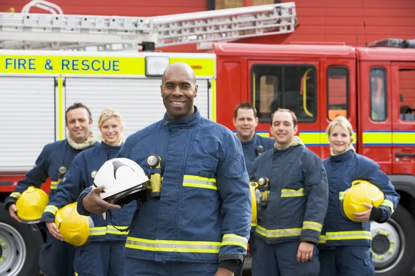 Retrato de um grupo de bombeiros por um carro de bombeiros — Fotografia de Stock