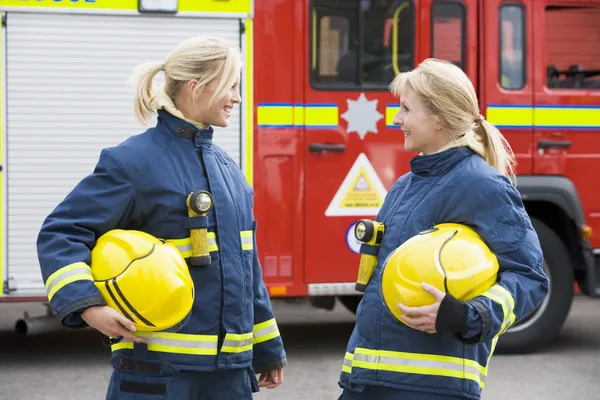 Két női tűzoltók által egy tűzoltóautó — Stock Fotó