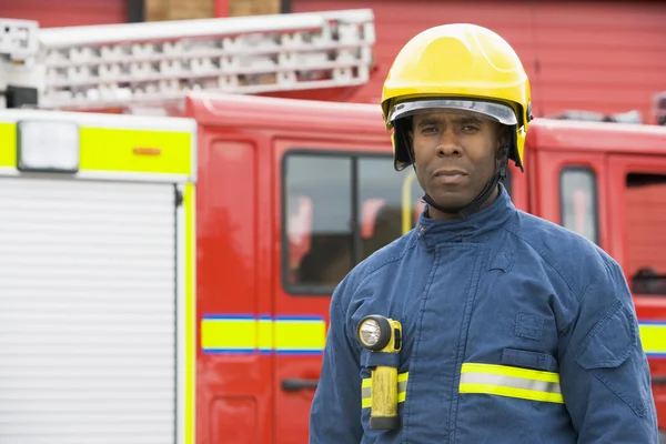 Портрет пожарного, стоящего перед пожарной машиной — стоковое фото