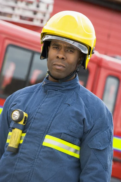 Portrait of a firefighter standing in front of a fire engine — Stock ...