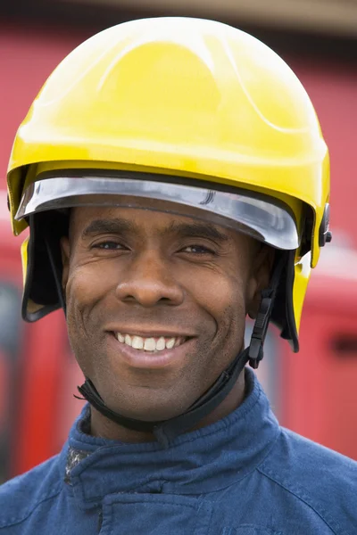 Portrait of a firefighter standing in front of a fire engine — Stock Photo, Image