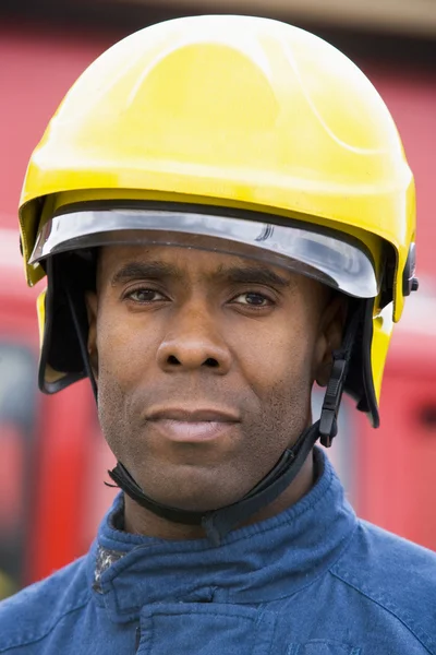 Retrato de un bombero parado frente a un camión de bomberos — Foto de Stock