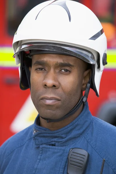 Retrato de um bombeiro à frente de um carro de bombeiros — Fotografia de Stock