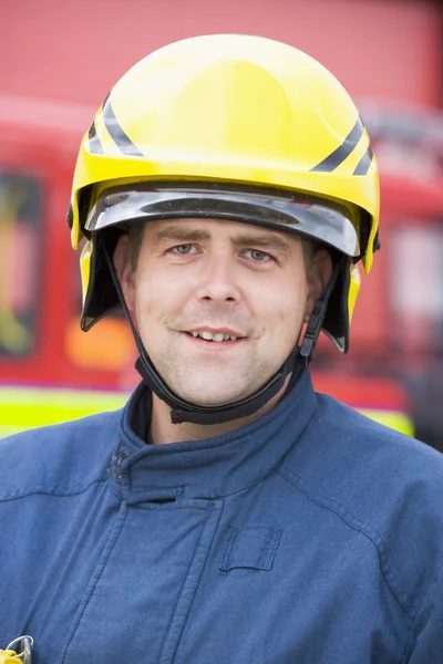 Retrato de un bombero parado frente a un camión de bomberos — Foto de Stock