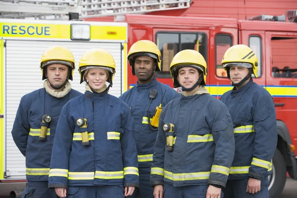 Retrato de un grupo de bomberos por un camión de bomberos — Foto de Stock