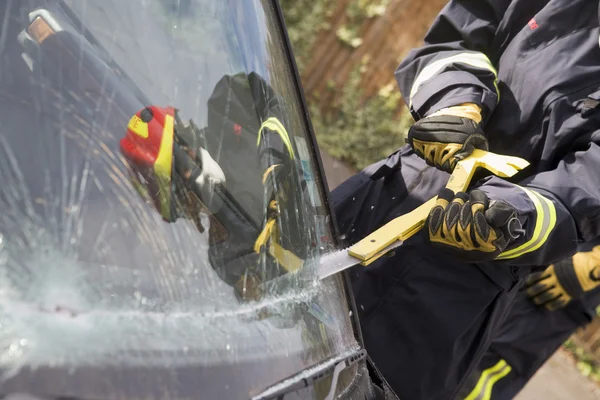 Les pompiers cassent un pare-brise de voiture pour aider un accident de voiture victi — Photo