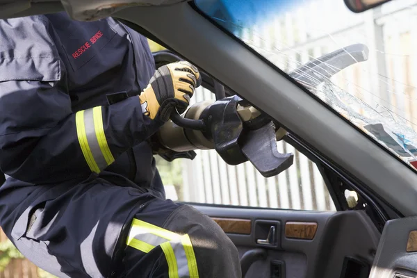 Tűzoltók törés egy autó szélvédő, hogy segítsen egy autó baleset victi — Stock Fotó