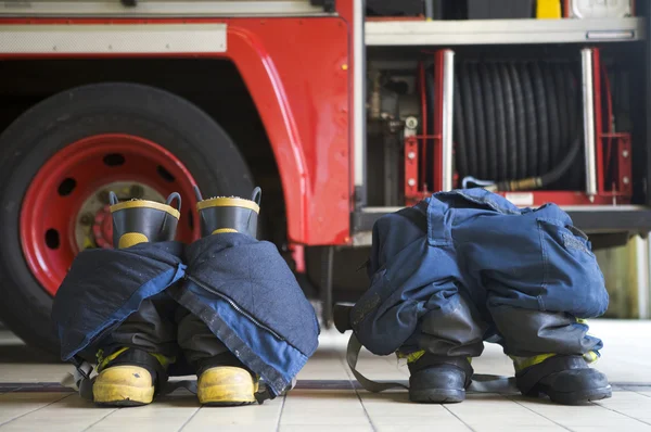 Firefighter's boots and trousers in a fire station — Stock Photo, Image