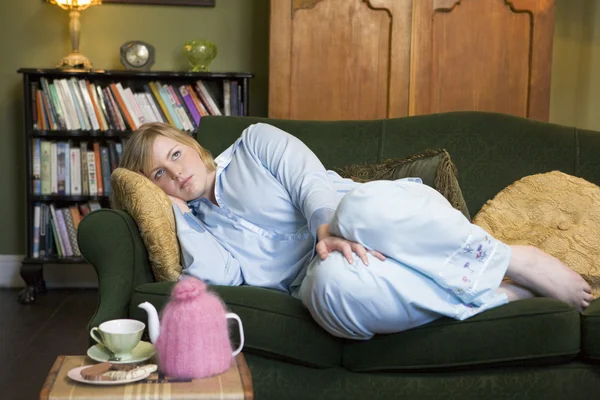 Una giovane donna sdraiata sul suo divano — Foto Stock