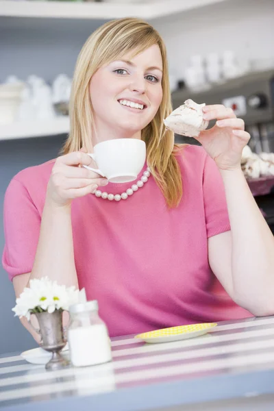 Uma jovem sentada em um café bebendo chá — Fotografia de Stock