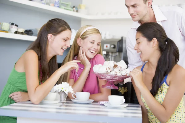Kawiarnia kelner oferuje młodych kobiet teacakes — Zdjęcie stockowe