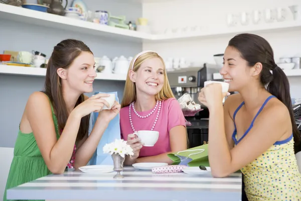 Jonge vrouwen genieten van thee in een café — Stockfoto