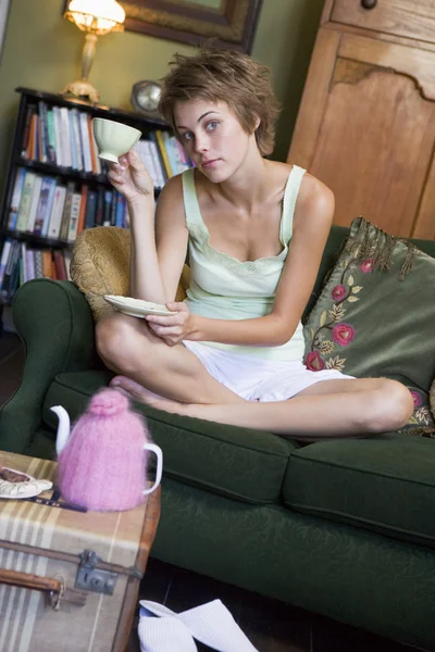 Çay Içme Onu Kanepede Oturan Genç Bir Kadın — Stok fotoğraf