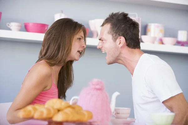 Mladý pár, tvrdí u stolu se snídaní — Stock fotografie