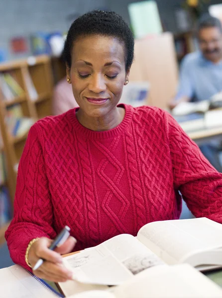 Volwassen vrouwelijke student studeert in bibliotheek — Stockfoto