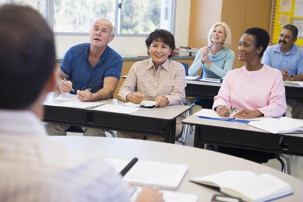 Äldre elever och deras lärare i ett klassrum — Stockfoto