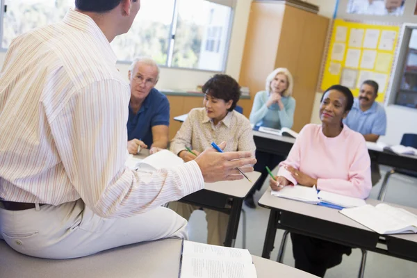 Mature students and their teacher in a classroom — Stock Photo, Image