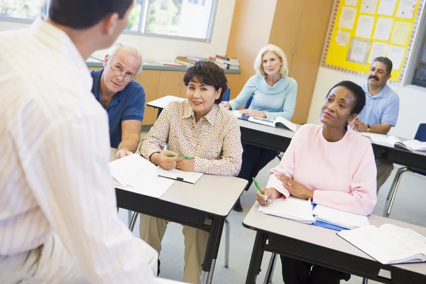 Mature students and their teacher in a classroom — Stock Photo, Image