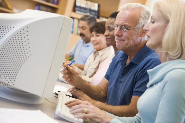 Зрелые студенты изучают компьютерные навыки — стоковое фото