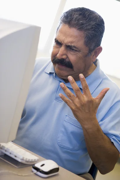 Mature male student expressing frustration at computer — Stock Photo, Image