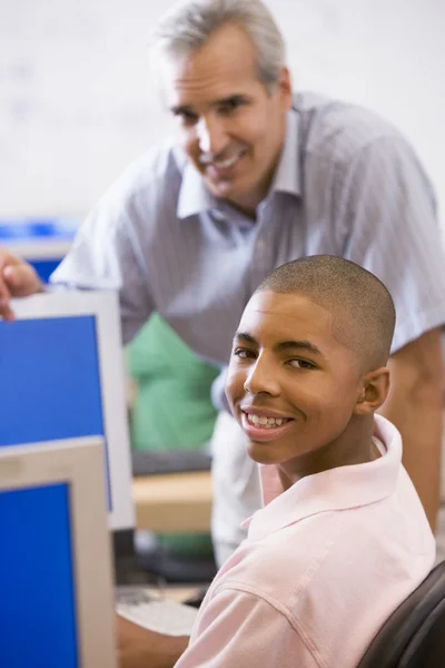 Ένας δάσκαλος συνομιλίες με μαθητής χρησιμοποιώντας έναν υπολογιστή σε ένα γυμνάσιο — Φωτογραφία Αρχείου