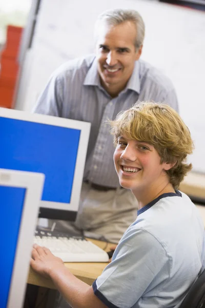 先生が高校で コンピューターを使用して 男子生徒に話して — ストック写真