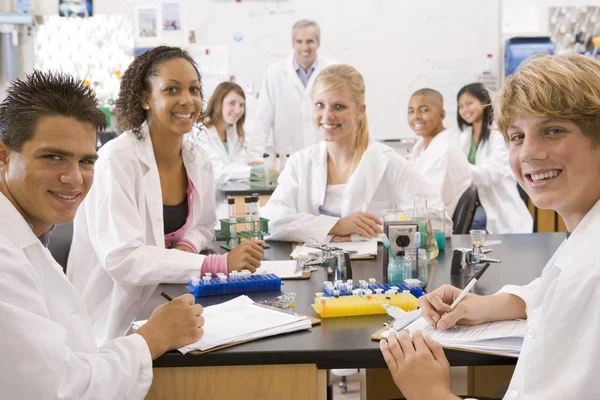 Schoolgaande kinderen en hun leraar in een middelbare school wetenschap klasse — Stockfoto