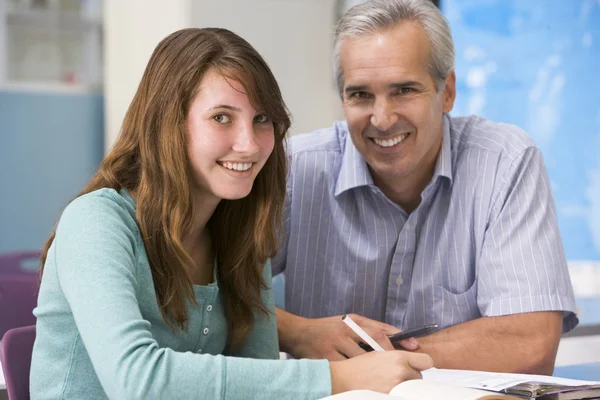 En lärare instruerar en skolflicka i en gymnasieklass — Stockfoto
