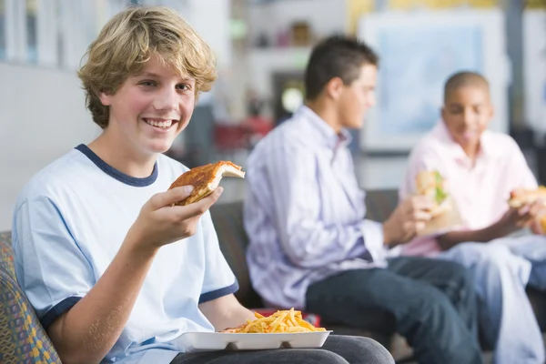Tienerjongens genieten van fastfood lunches samen — Stockfoto
