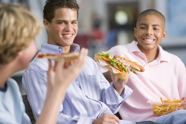 Teenage boys enjoying fast food lunches together — Stock Photo, Image